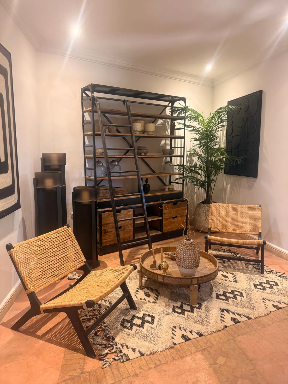 Reading corner with rattan armchairs and iron bookcase